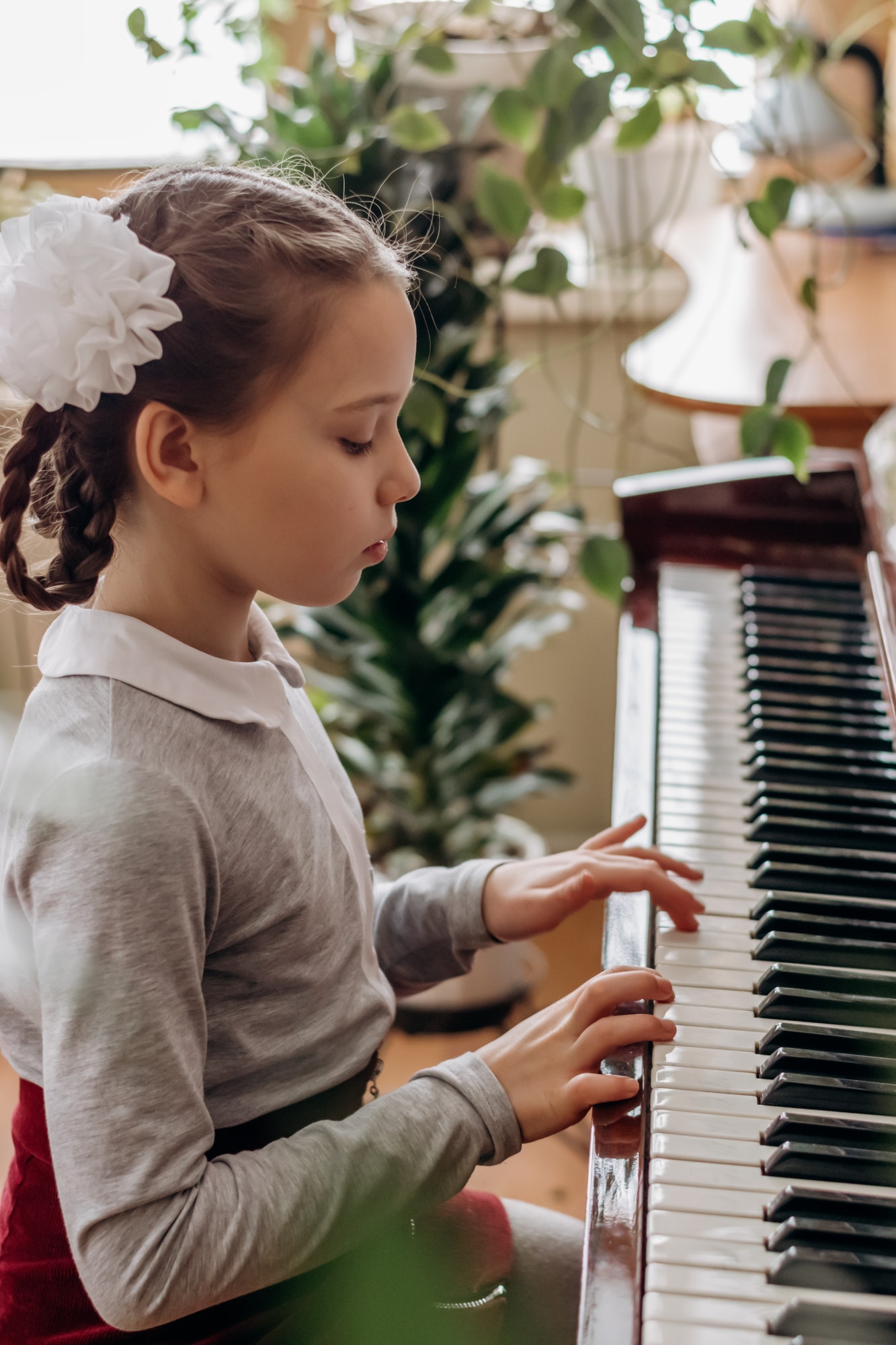 A girl with pigtails plays the piano.